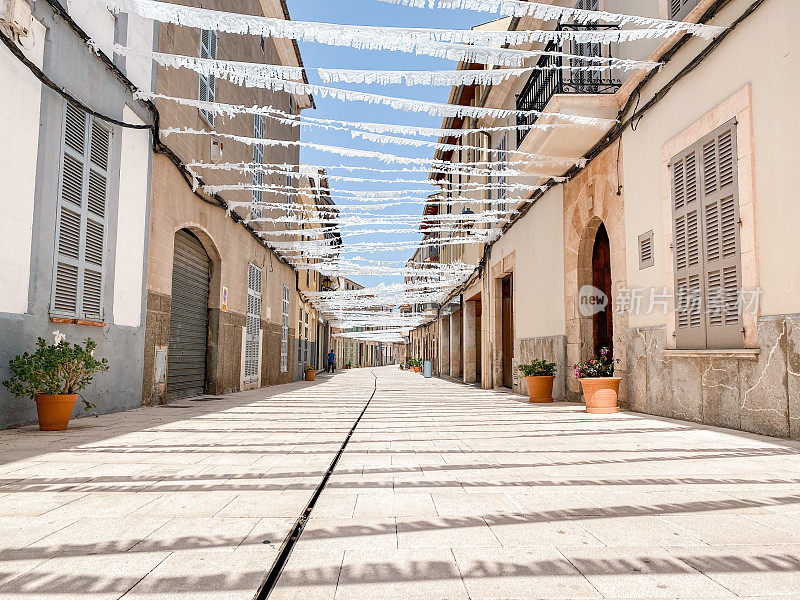 夏天镇上空荡荡的街道上挂着白色的纸，用于庆祝流行的节日