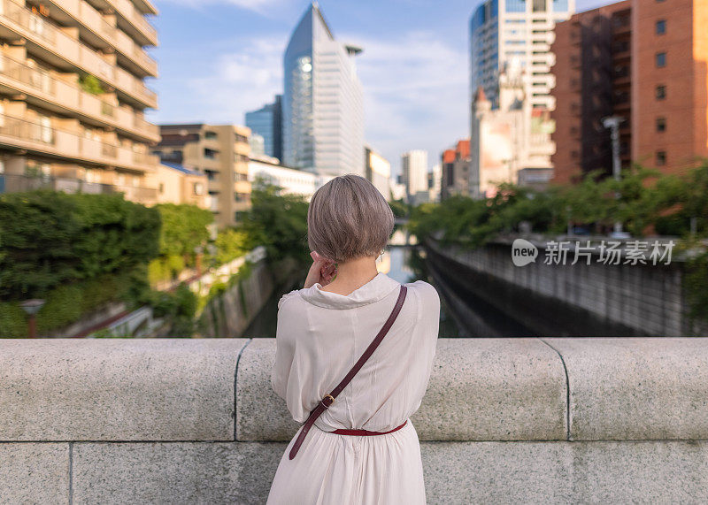 站在石桥上的年轻女子的背影