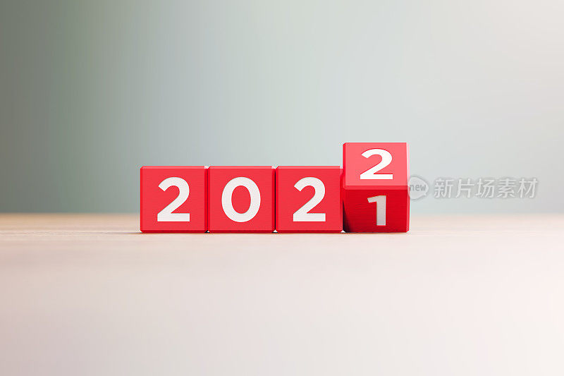 “2021”和“2022”书写的红色木块坐在前木表面散焦背景