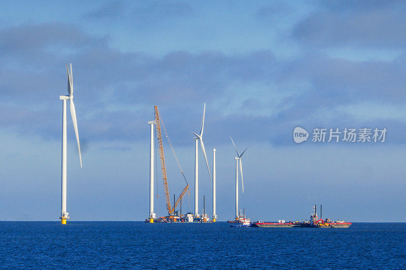 建设海上风电场-荷兰海上风力涡轮机(markmeer)。吊船正准备吊起风力涡轮机的转子。晴朗的天气和大气的心情。