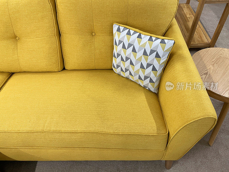 近景现代，黄色软垫沙发与图案，灰色，白色和黄色抛靠垫，提高视野，聚焦前景