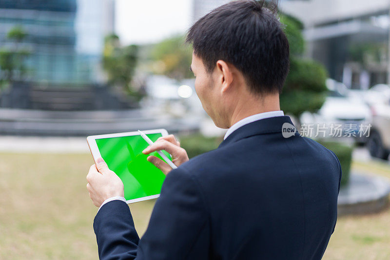 一名亚洲男子正在使用智能平板电脑