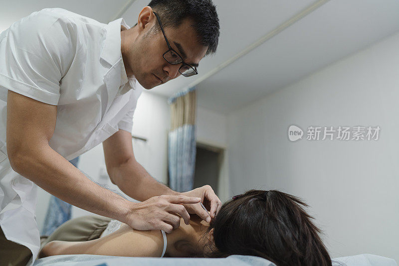 中医疗法——亚洲女性患者接受背部针灸治疗
