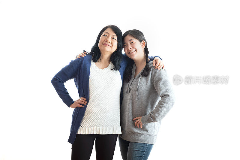 成熟的亚洲母亲和成年欧亚女儿抬头，拥抱