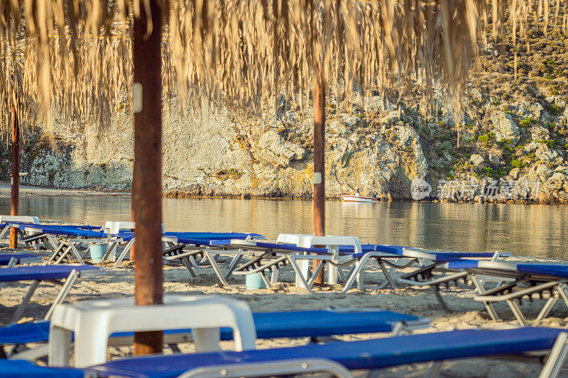 在希腊莱姆诺斯岛的海滩上的沙滩躺椅和雨伞。