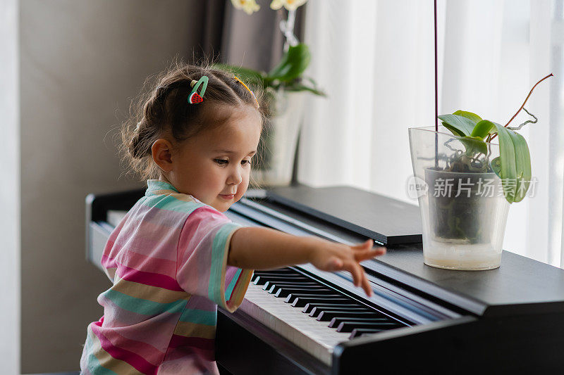 可爱的小女孩在音乐学校弹钢琴。