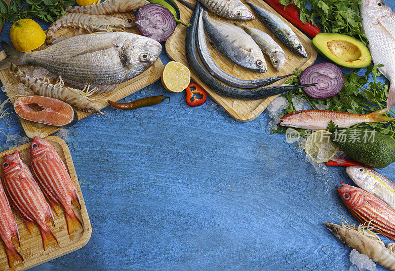 各种新鲜的鱼和海鲜在蓝色的木材上的高角度视角