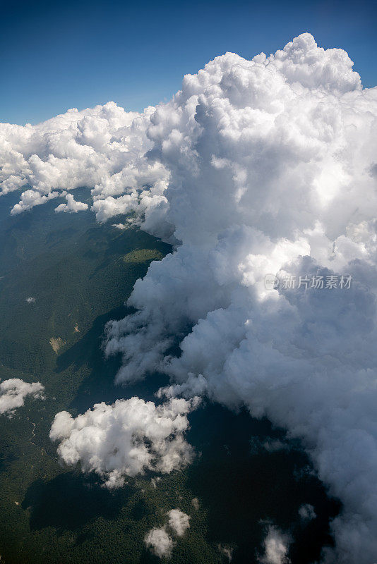 从飞机视角鸟瞰山脉上空的巨大云层