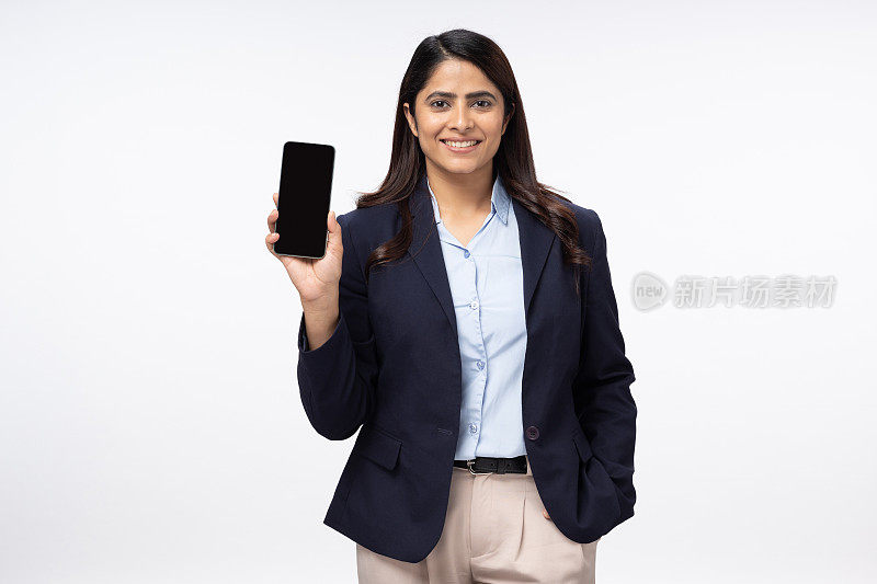 快乐的年轻女商人展示智能手机，白色背景上的空屏幕，库存照片