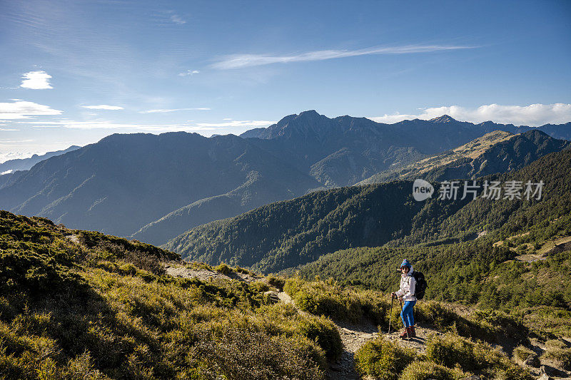 徒步旅行者站在山顶上看风景。