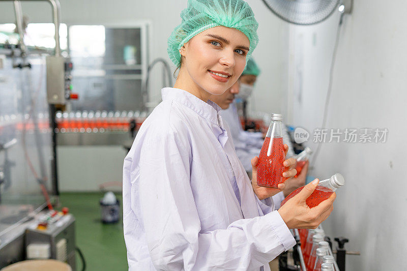 质量控制工程师在果汁或药品的生产和装瓶设备中工作。员工在食品和药品交付给客户之前检查其质量。