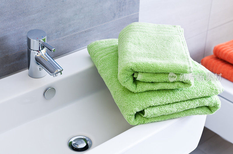 浴室水槽和两条绿色毛巾