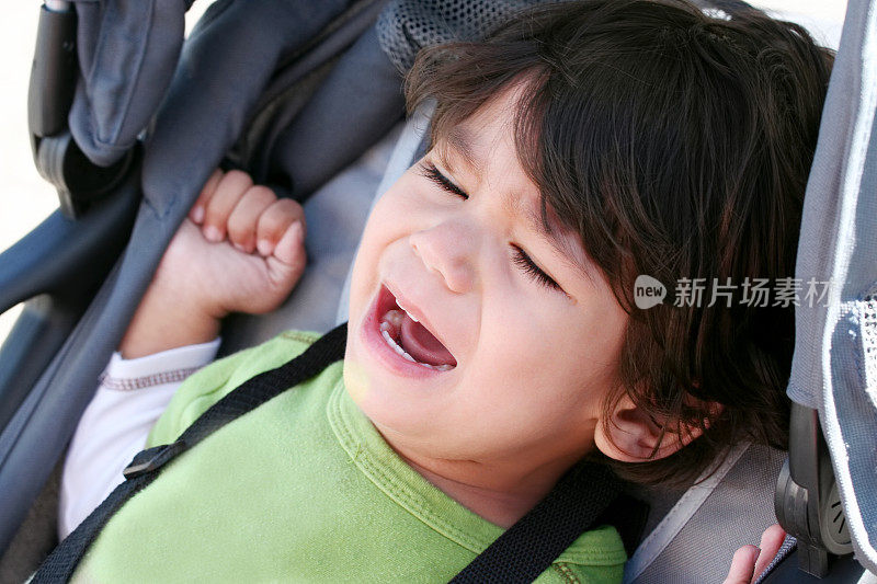 不幸的婴儿在婴儿车里哭泣