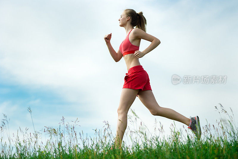 年轻女子跑着夏天公园乡村路。户外运动。J
