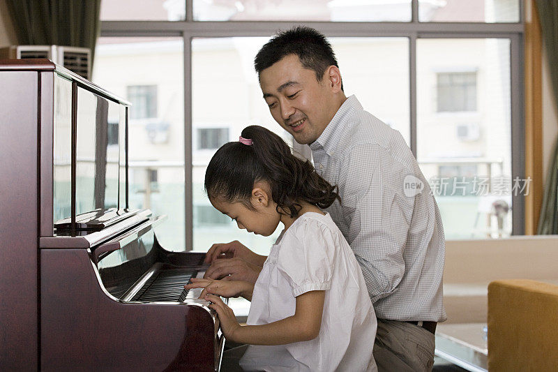 父亲和女儿在弹钢琴