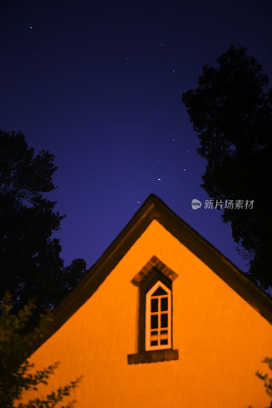 星星在夜晚的天空，在树和房子上面