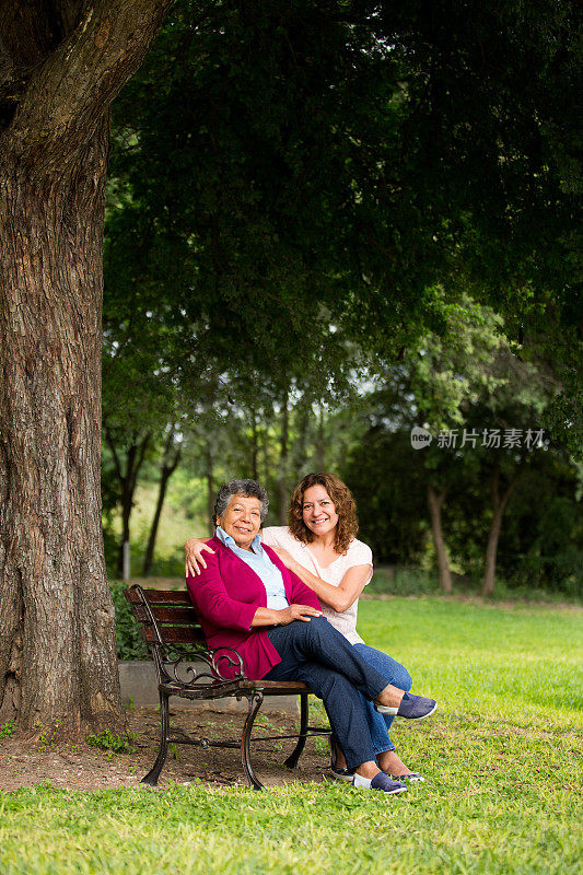 年迈的母亲和她的女儿坐在公园里