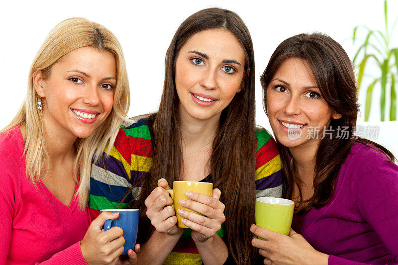 三个年轻女人微笑着喝着咖啡