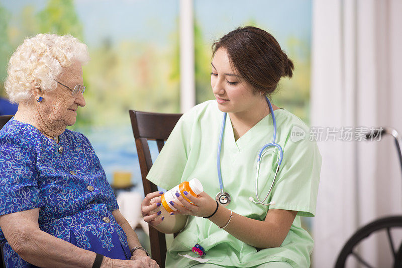 家庭保健护士向老年妇女解释处方药物。