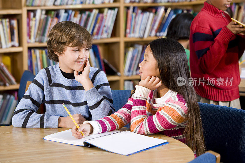 男孩和女孩一起在图书馆学习