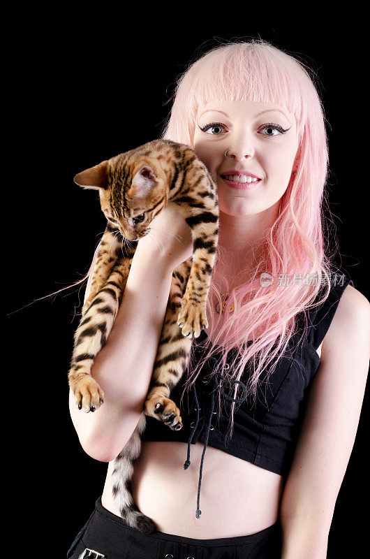 粉红头发的年轻女子抱着孟加拉小猫