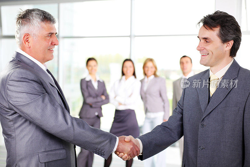 商务人士在办公室见面握手。