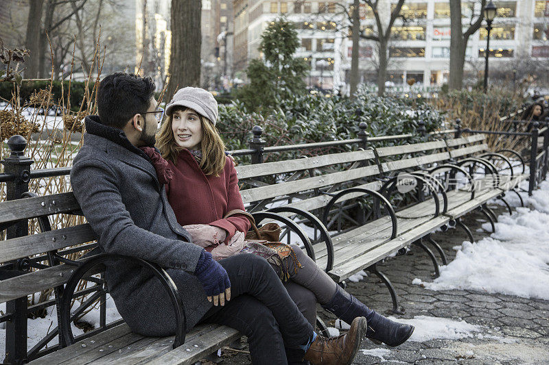 相爱的多民族情侣坐在公园长椅上