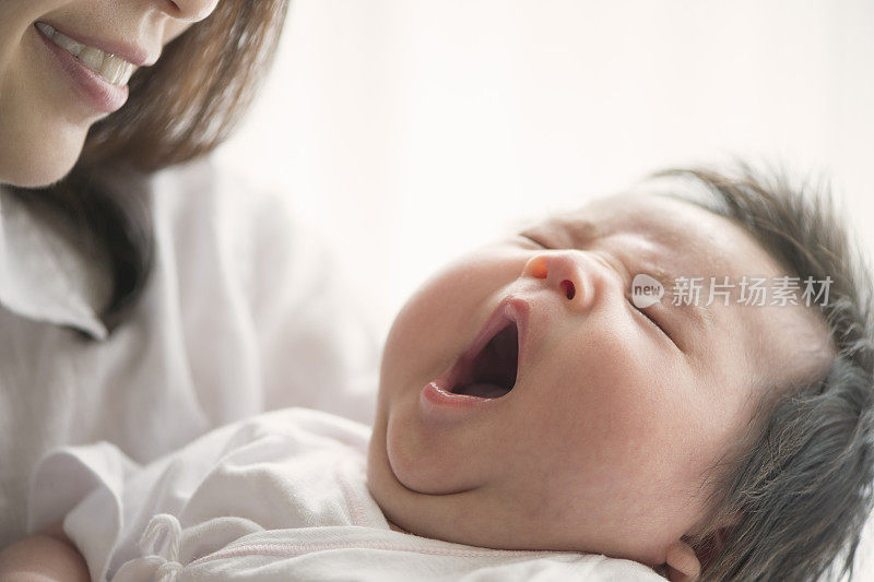 年轻的母亲在家里爱着她的宝贝女儿