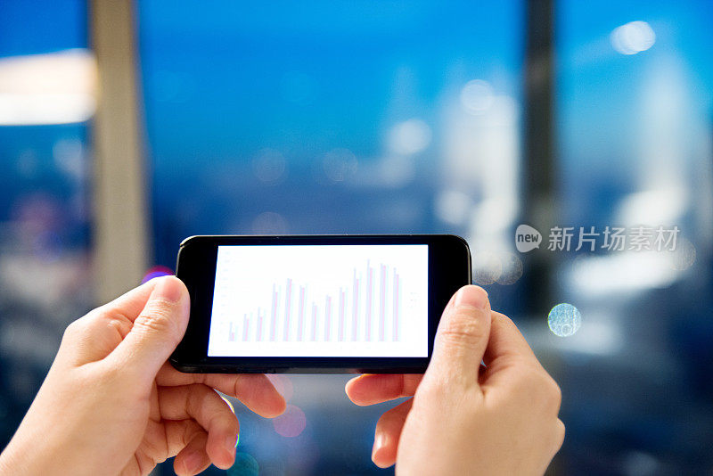 手持智能手机与业务图表-股票图像