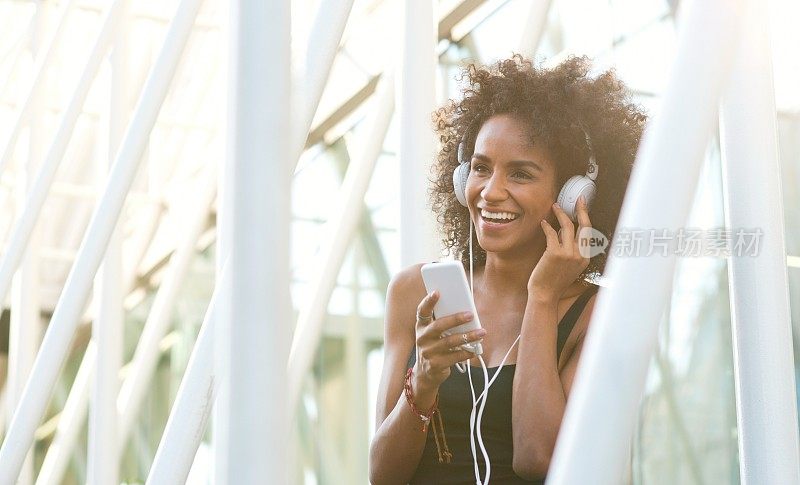 微笑的非洲裔美国妇女在听音乐。