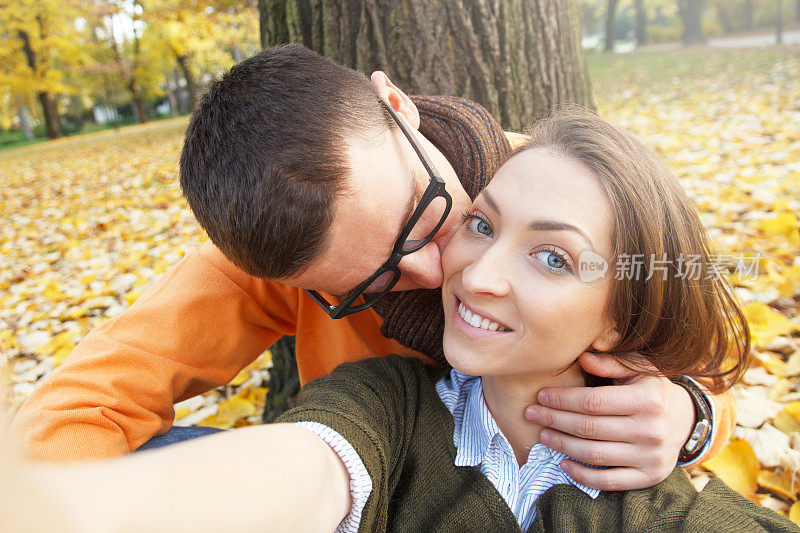 一对年轻情侣在公园接吻的自拍
