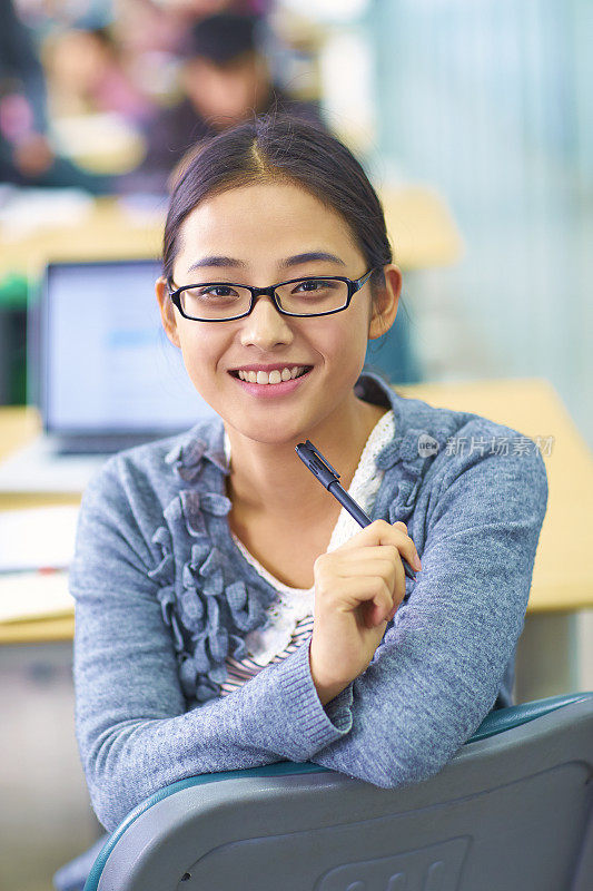 一个漂亮的亚洲大学生对着相机微笑的肖像