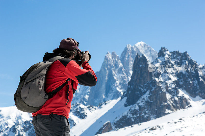 男摄影师用单反相机拍摄山脉