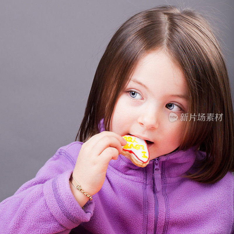 漂亮的小女孩在吃饼干