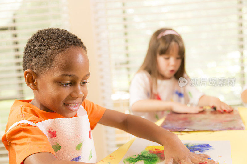 儿童:多民族学校儿童在美术课上手指画。