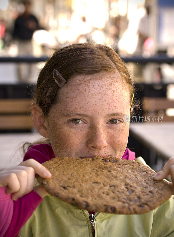 吃大饼干的孩子，不健康的食物，餐馆里的红发女孩