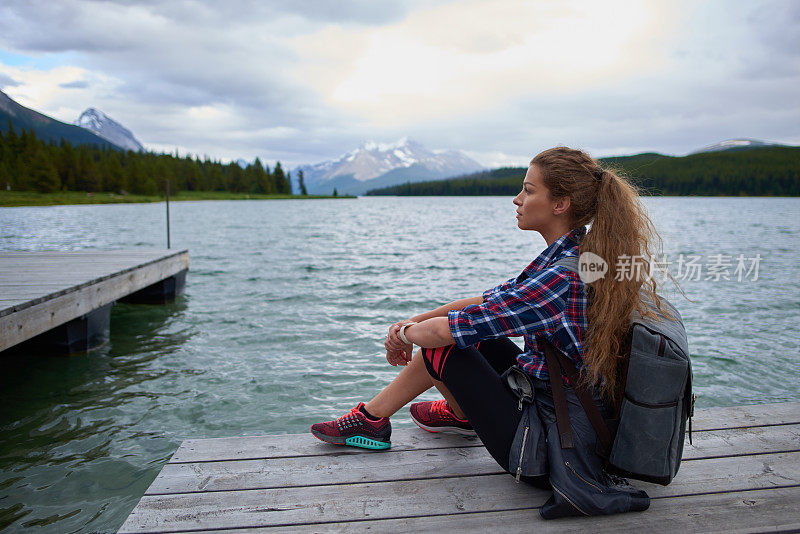 年轻漂亮的女人在湖边徒步旅行