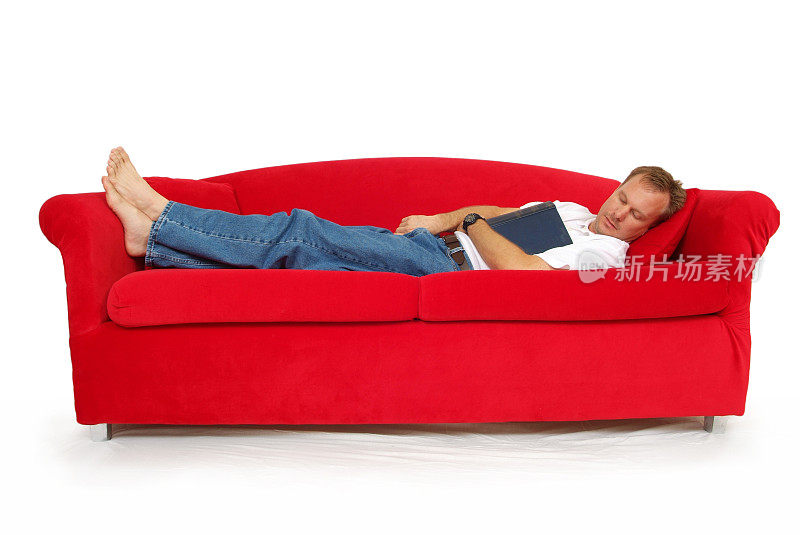 一个在红色沙发上看书的中年男人