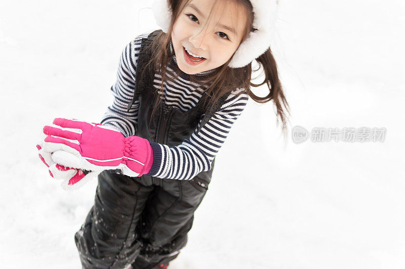 美丽的小女孩在雪地里开心地笑着