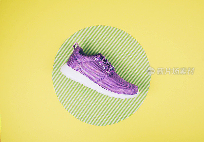 淡紫色的运动鞋在一个多颜色柔和的表面。俯视图，时尚风格。