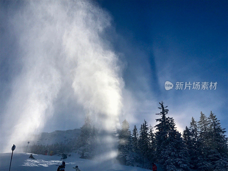 美丽的高山景观和天空与雪尘照亮阳光