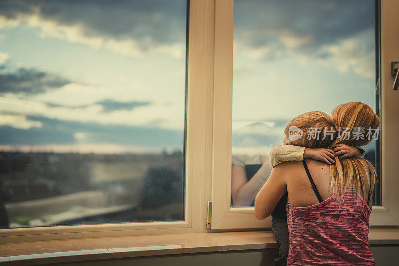 忧郁时，在窗边深情地拥抱着母子