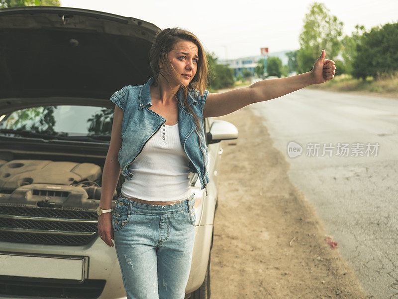 一名女子的车在路上抛锚了，她做出了停止的手势