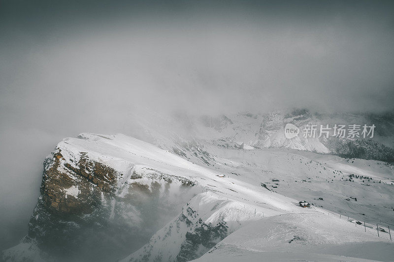 风景冬季的雾塞达山和偏僻的小木屋白云石阿尔卑斯山