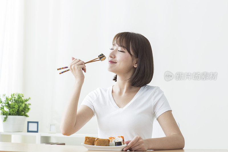 年轻女人吃寿司