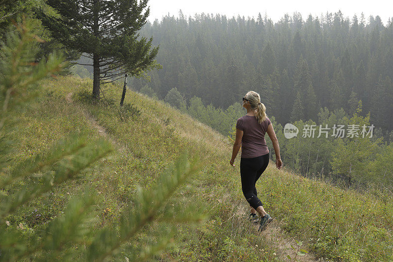 女性徒步旅行者沿着小路行走