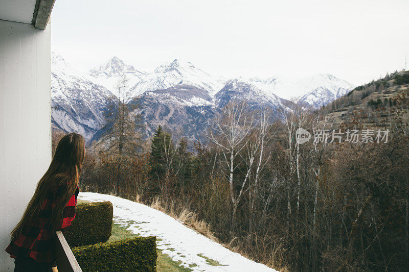 从窗口欣赏瑞士阿尔卑斯山景色的女人
