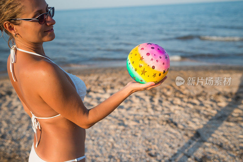 在海边玩球的女孩。