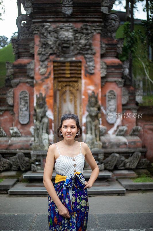 年轻女子在巴厘岛古庙附近自拍