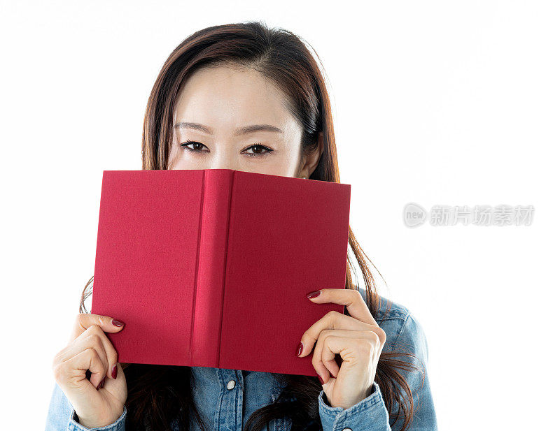 一个女人躲在一本白色背景的书后面
